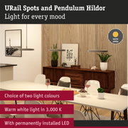 Modern grey pendant lights with warm white LED light above dining table in wooden interior