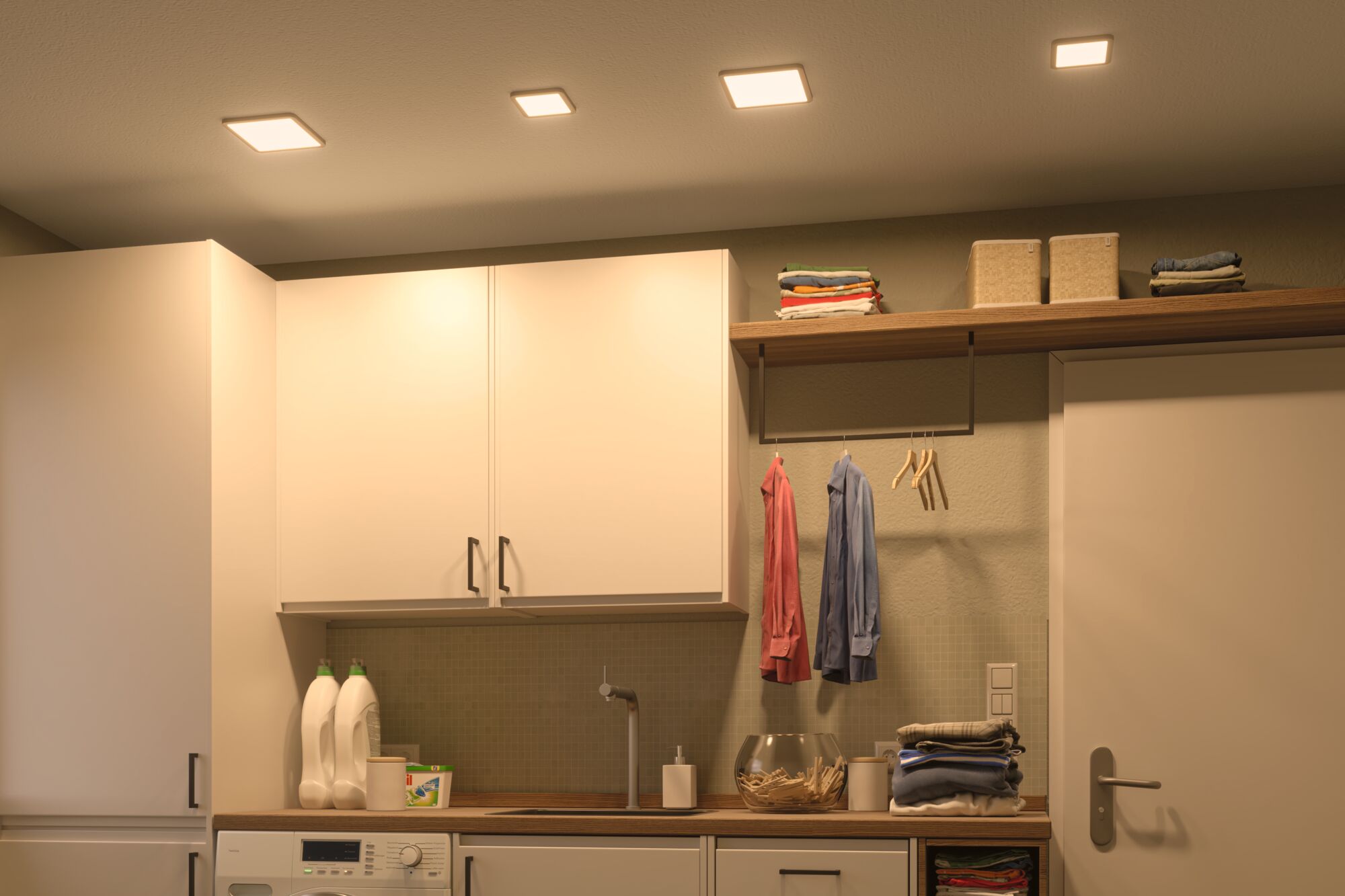 Moderne weiße Küchenschränke mit Holzarbeitsplatte und warmweißen LED-Deckenleuchten für Wohnraumbeleuchtung.