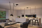 Modern open kitchen with white wood island, black bar stools, and minimalist black pendant light fixture