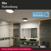 Modern badkamerinterieur met zwarte kranen, groene marmeren wastafel en ronde plafondlampen