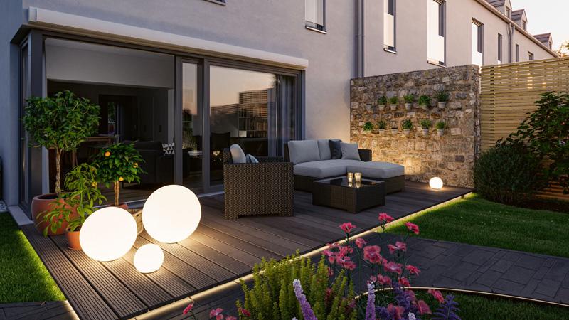 Sphères lumineuses extérieures modernes sur terrasse avec mobilier lounge et plantes de jardin, éclairage LED.
