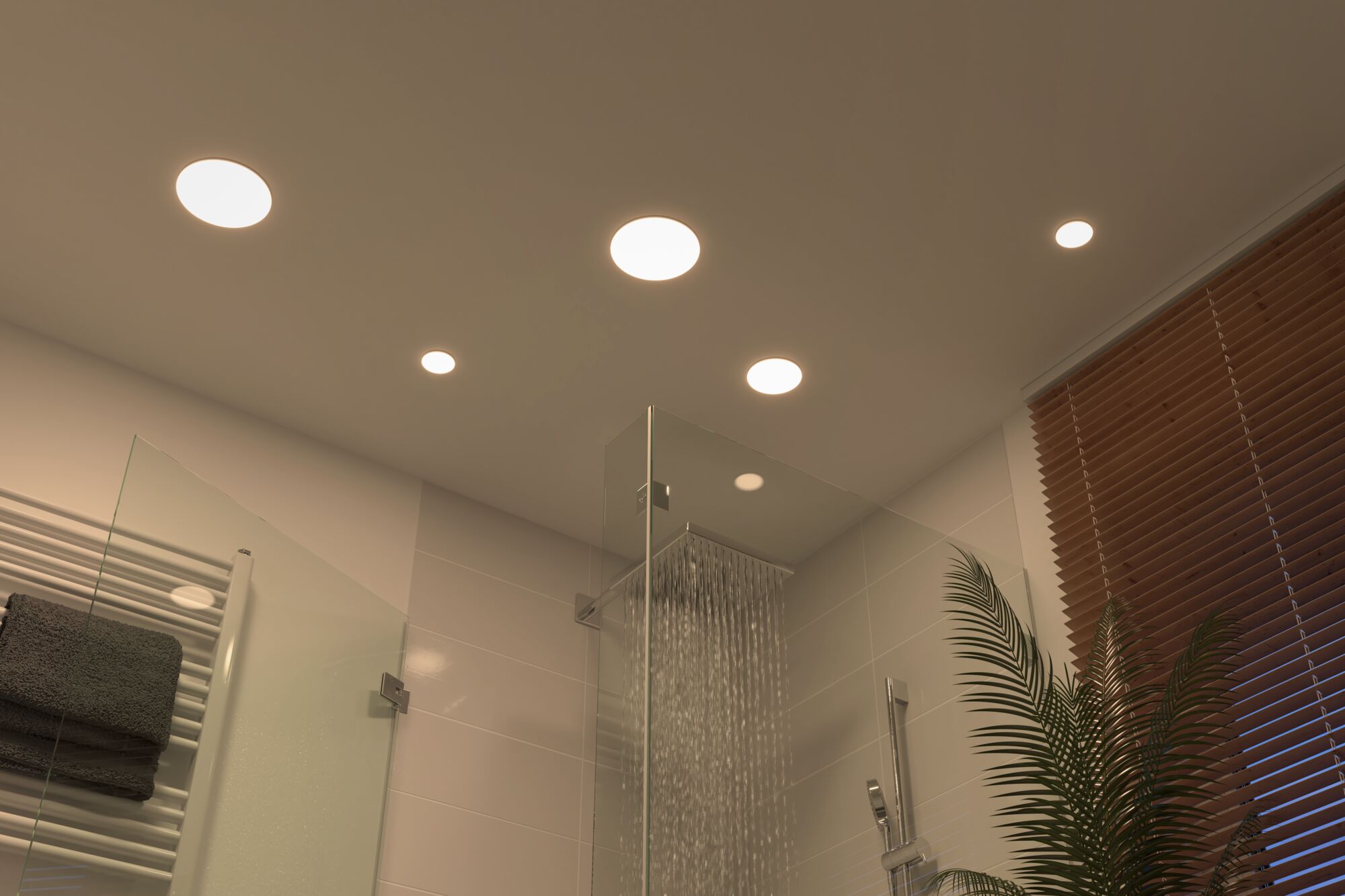 Quatre spots LED encastrés ronds blancs au plafond de salle de bain avec douche moderne et stores en bois