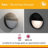 Applique murale solaire ronde noire avec détecteur de mouvement sur mur clair et sombre, éclairage extérieur économique