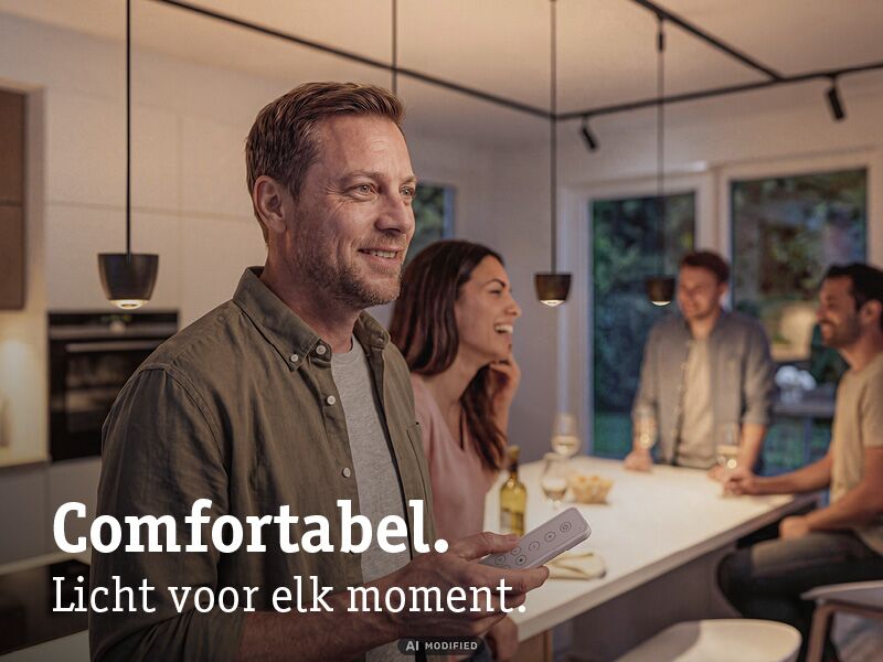 Man bedient moderne zwarte hanglampen in gezellige keuken met afstandsbediening voor sfeerverlichting.