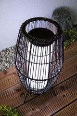Moderne zwarte metalen draadlantaarn met wit licht op houten terras voor buitenverlichting
