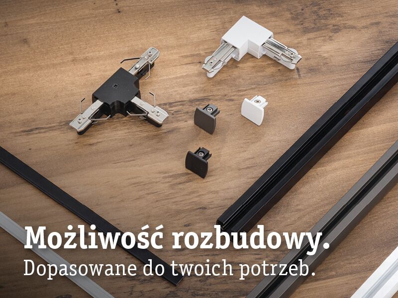 Czarne i białe łączniki oraz zaślepki aluminiowe do systemu szyn URail na drewnianym tle.