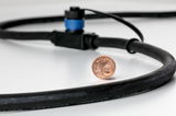 Schwarzes Kabel mit blauem Anschluss und 1-Cent-Münze zum Größenvergleich auf weißem Untergrund