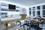 Modern café interior with wood and white elements, LED lighting, and stylish seating areas for guests.