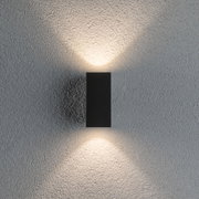 Schwarze LED-Wandleuchte aus Metall mit warmweißem Licht auf strukturierter grauer Wand