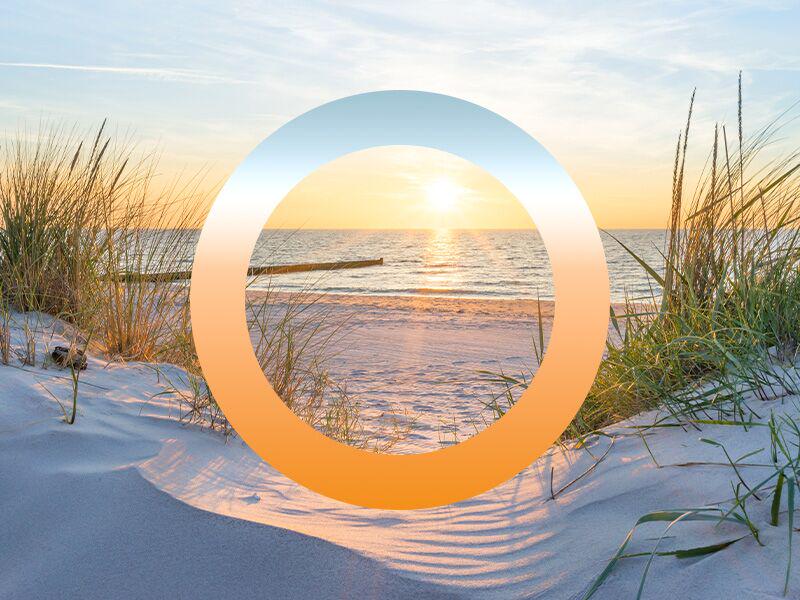 Zonsondergang op het strand met zandduinen en gras, symbool voor daglichtregeling en HCL-verlichting