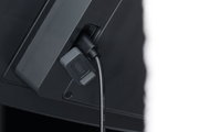 Black charging cable with grey cover connected to a black electronic device for power supply