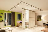 Modern living room with white ceiling track system and adjustable LED spotlights for flexible lighting