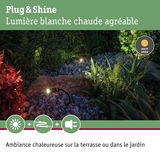Projecteurs LED Plug & Shine blanc chaud éclairant galets et plantes pour ambiance chaleureuse extérieure.