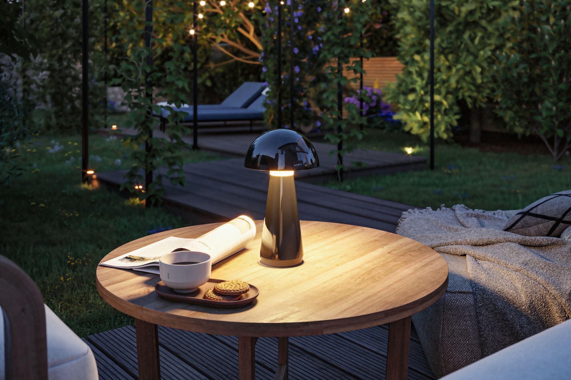 Schwarze LED-Tischleuchte aus Metall auf Holztisch im Garten mit Tasse, Keksen und Zeitung bei Abendlicht