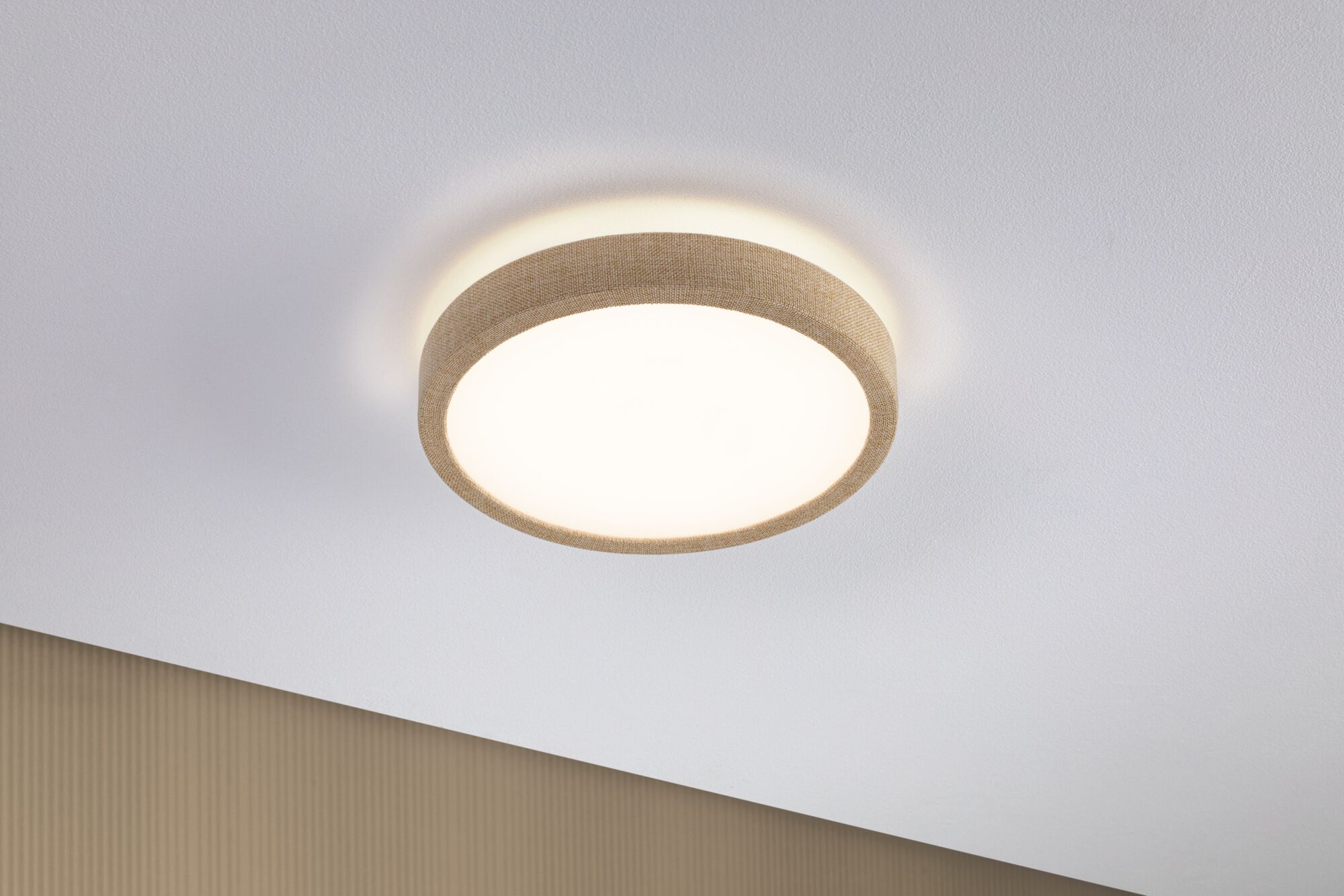 Round ceiling light with beige fabric edge and warm white light for modern interiors
