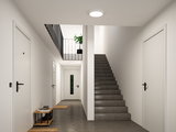 Round white LED ceiling light in modern stairwell with grey floor and white walls