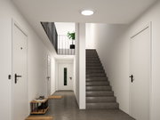 Rundes weißes LED-Deckenlicht in modernem Treppenhaus mit grauem Boden und weißen Wänden