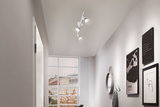 Moderne witte plafondspot met drie LED-lampen in hal met spiegel en wanddecoratie.