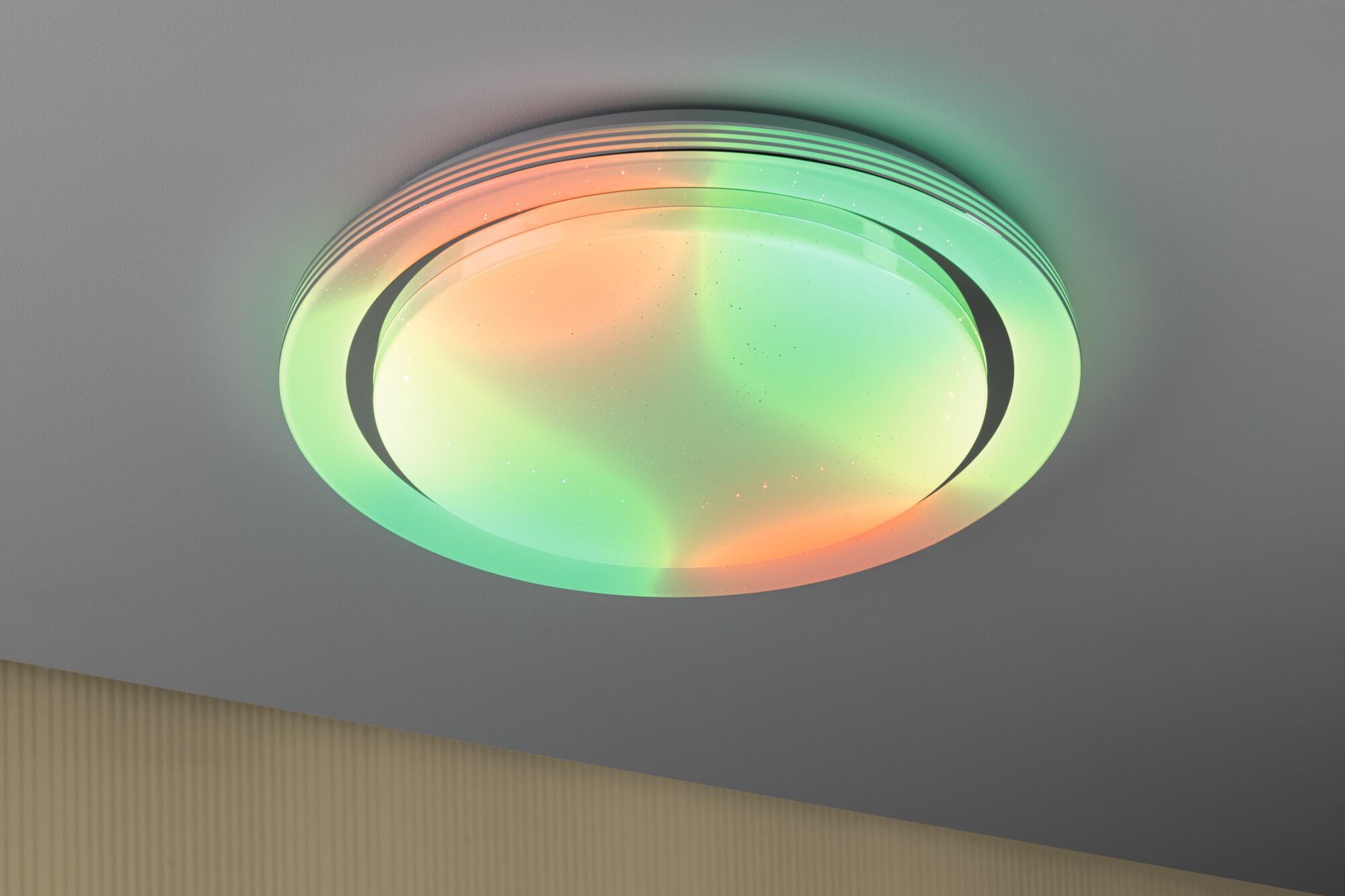 Round ceiling light with RGB color change and white housing for modern living spaces.