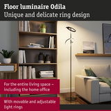 Black floor lamp Odila with adjustable light rings in modern living room with bookshelf and sofa
