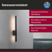 Schwarze LED-Wandleuchte mit seewasserresistenter Oberfläche an grauer Wand mit Meerblick