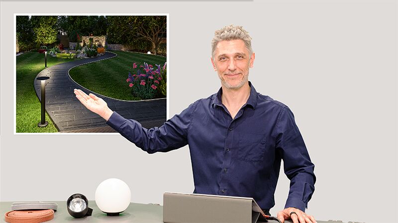 Mann präsentiert Gartenweg mit LED-Außenleuchten und Beleuchtungskörpern auf Tisch im Webinar-Setup