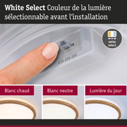 Doigt réglant la couleur de la lumière sur un interrupteur blanc, plafonnier LED dimmable avec cadre en bois