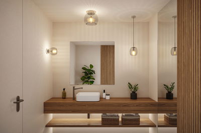 Modern bathroom with wooden vanity and three clear glass lights providing warm LED illumination