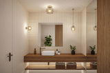 Modern bathroom with wooden vanity and three clear glass lights providing warm LED illumination