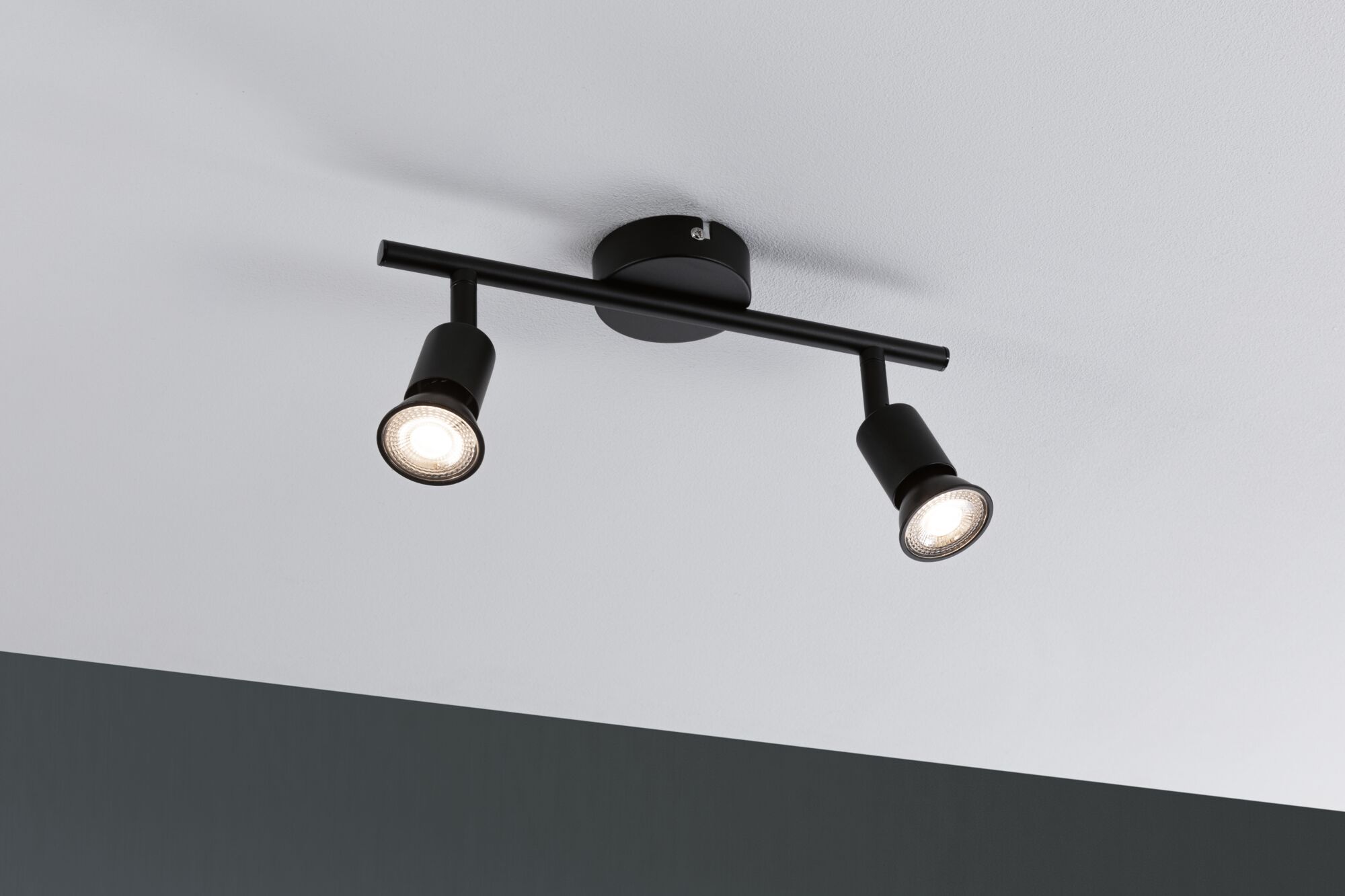 Black ceiling light with two adjustable metal spotlights for modern room lighting.