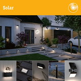 Black solar outdoor lights on house and garden path for energy-saving illumination