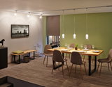 Modern dining area with wooden table, brown chairs, and three glass pendant lights on track system