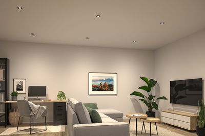 Six round LED recessed lights in white ceiling illuminate modern living room with grey sofa and wooden furniture.