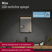 Moderne Miro LED-verlichte badkamerspiegel met zwarte rand en houten plank voor badkamerdesign.