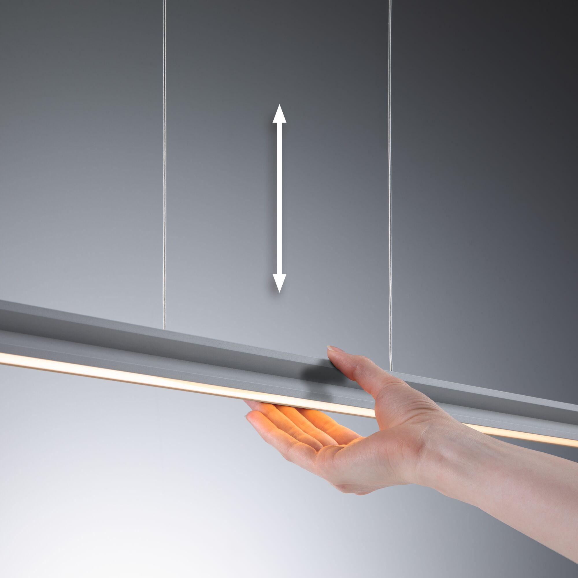 Hand holding grey LED pendant light with warm white illumination and adjustable height for interiors