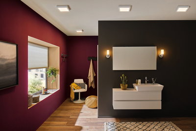 Modern bathroom with white wall lights and sink cabinet on black wall, wooden floor and red accent wall