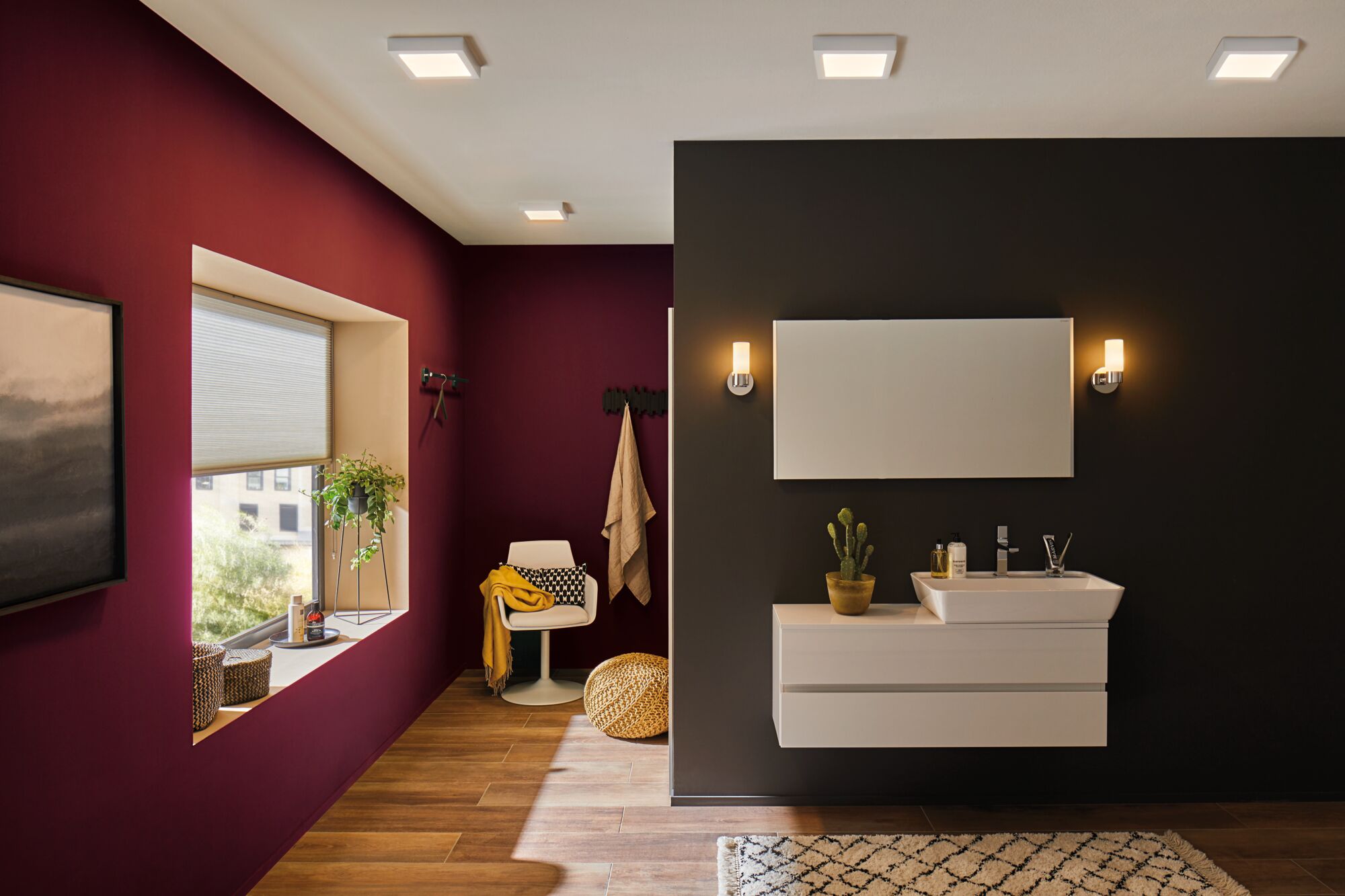 Moderne badkamer met witte wandlampen en wastafelmeubel tegen zwarte muur, houten vloer en rode accentmuur