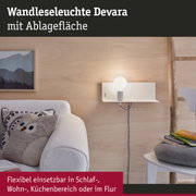 Weiße Wandleuchte Devara aus Metall mit Ablagefläche an hellem Holz im Wohnzimmer