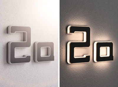 Modern house number 2a in black material with white LED lighting on wall shown day and night