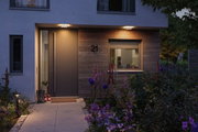 Modern front door with wood cladding and warm white LED outdoor lighting for garden and terrace.