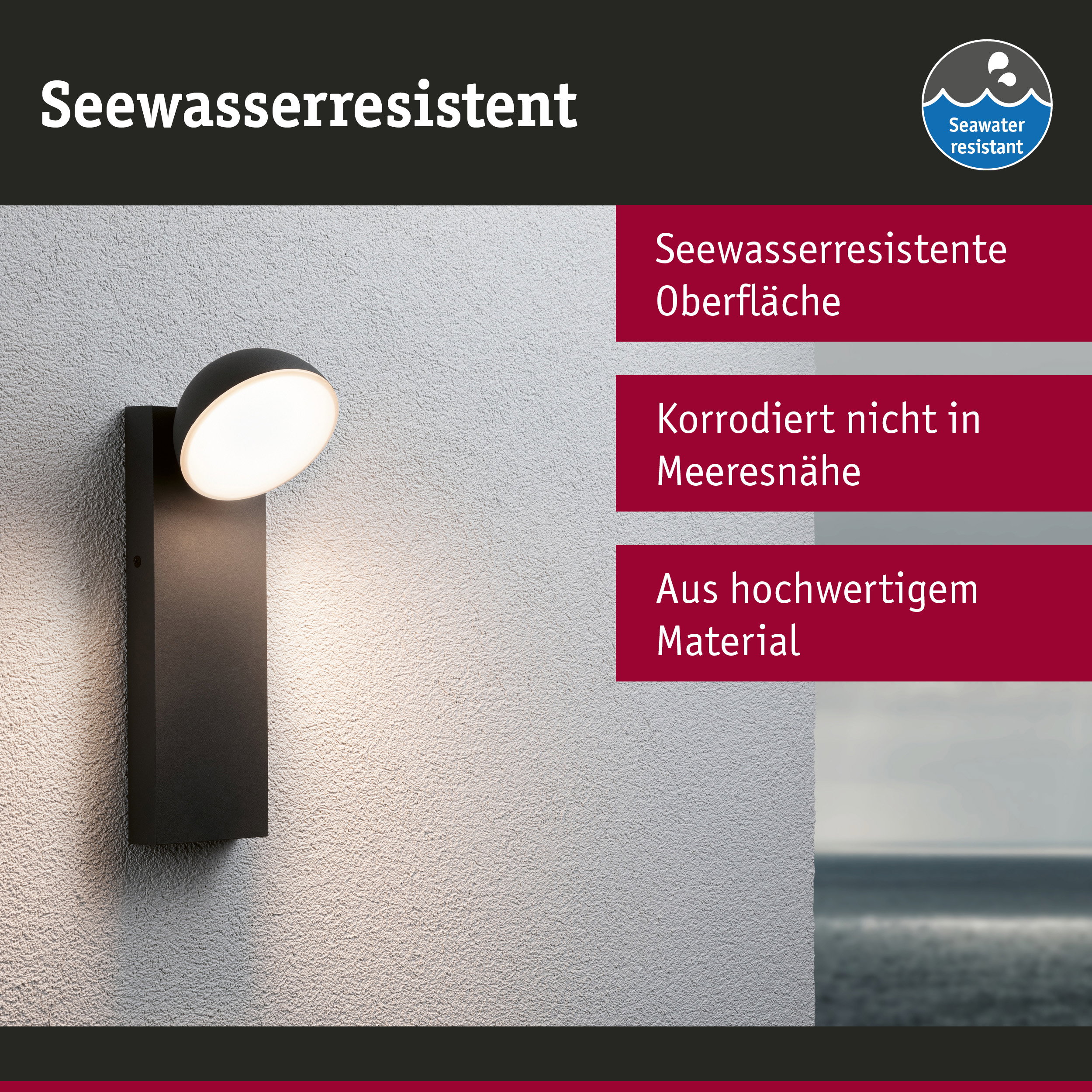 Schwarze Außenwandleuchte mit seewasserresistenter Oberfläche an grauer Wand mit Meerblick