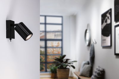 Black aluminum wall spotlight with ribbed design and warm white LED light for modern interior lighting