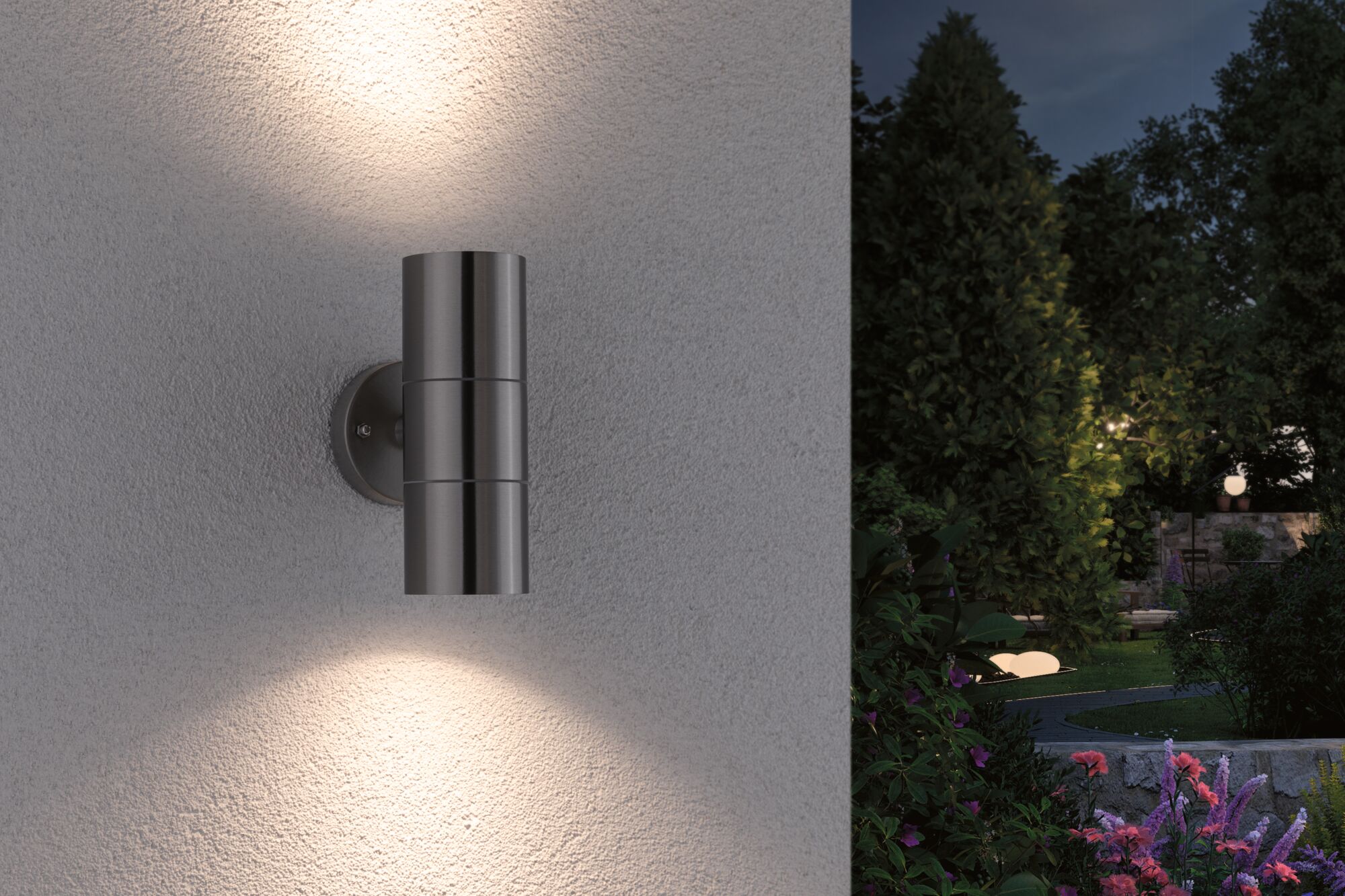Applique murale extérieure en acier inoxydable avec éclairage haut et bas sur mur blanc dans jardin la nuit