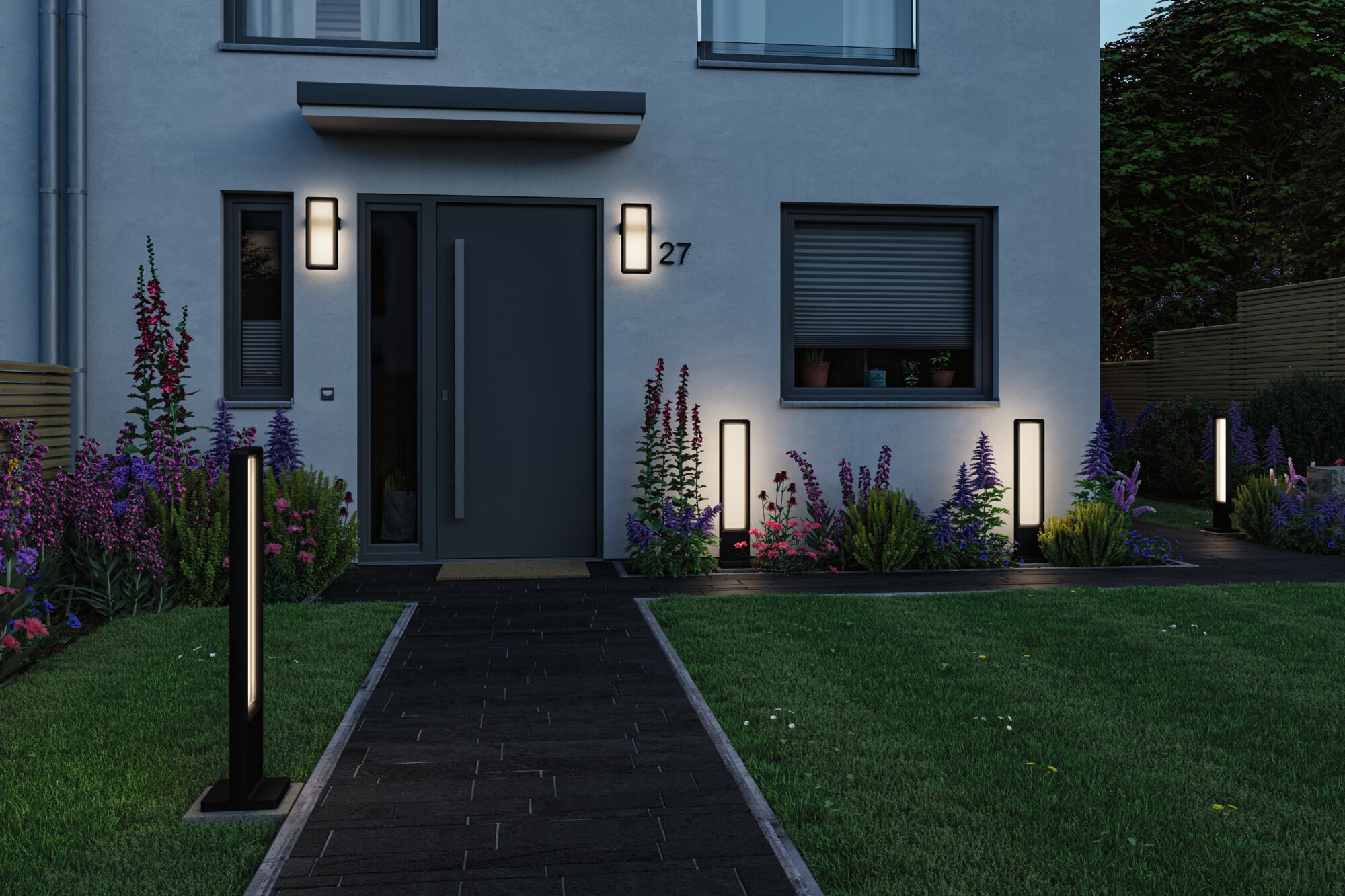 Luminaires extérieurs LED noirs modernes sur maison et chemin de jardin avec lumière blanche chaude pour éclairage extérieur ambiance.