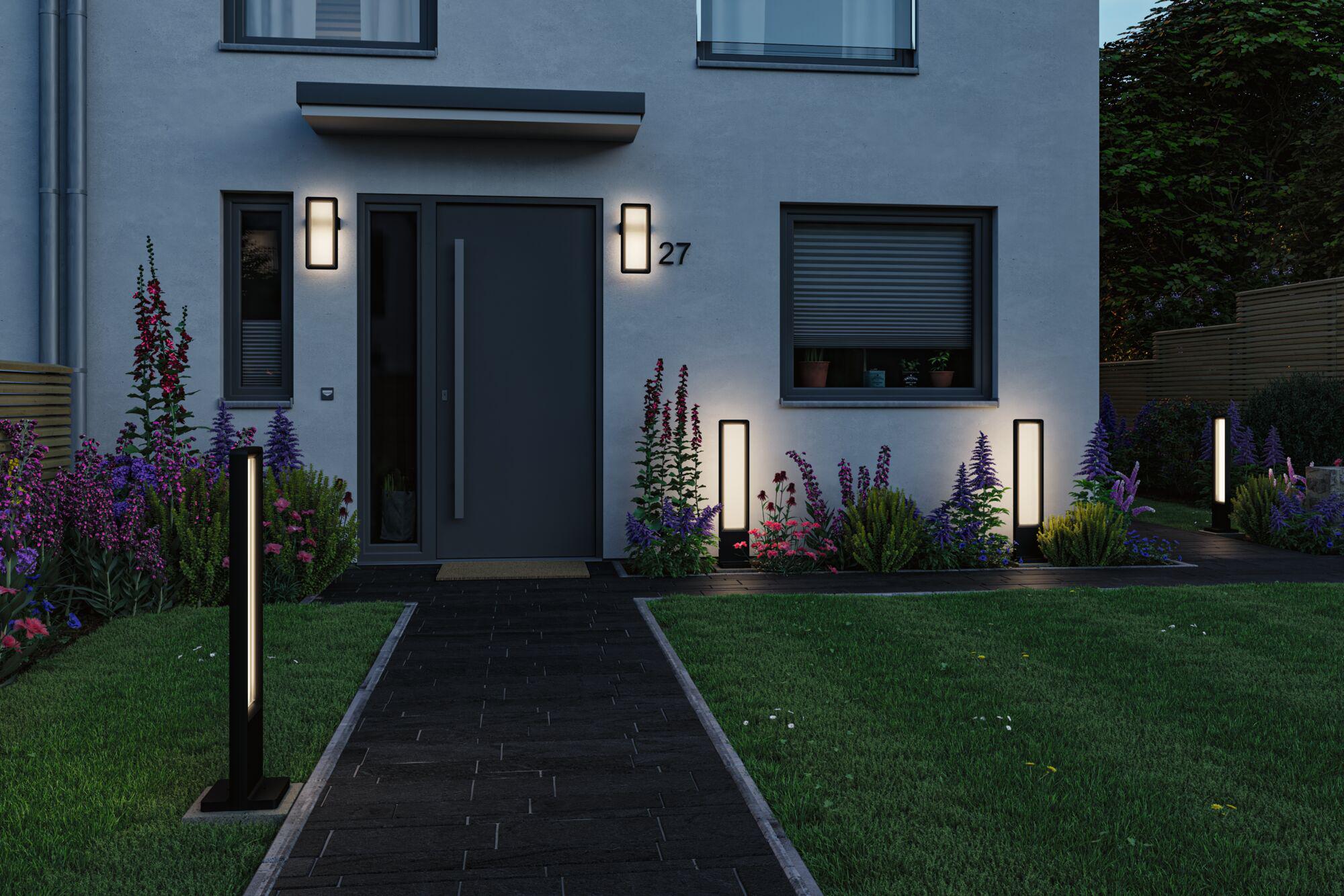Moderne schwarze LED-Außenleuchten an Haus und Gartenweg mit warmweißem Licht für stimmungsvolle Außenbeleuchtung.