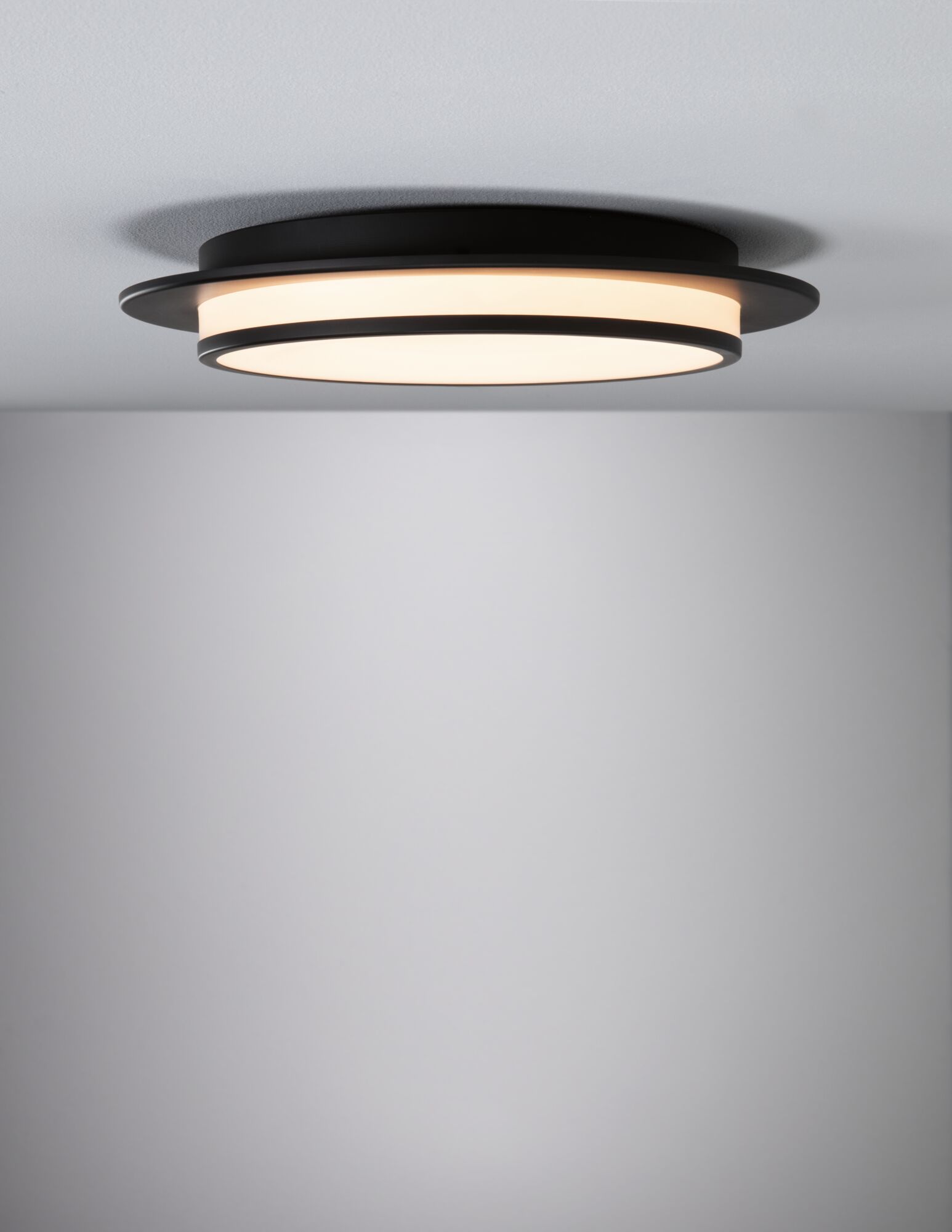 Rund loftlampe i sort metal med varmt hvidt LED-lys til moderne boligbelysning