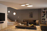 Salon moderne avec lampes rondes blanches au plafond et mur pour un éclairage LED d'ambiance