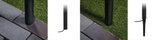 Installation of black metal ground sleeve with spike outdoors on grass and paving stones for garden lighting