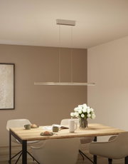 Modern silver metal LED pendant light above wooden table with flowers and tableware