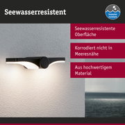 Schwarze Außenwandleuchte mit seewasserresistenter Oberfläche an weißer Wand mit Meerblick
